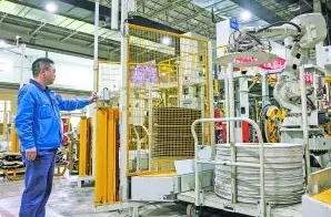 圖:工作人員在5G全連接工廠的成型區(qū)內操作機械手 圖:工作人員在5G全連接工廠的成型區(qū)內操作機械手